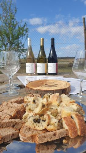 a table with bread and wine glasses and wine bottles at Domaine de l'Envolée in Tourbes
