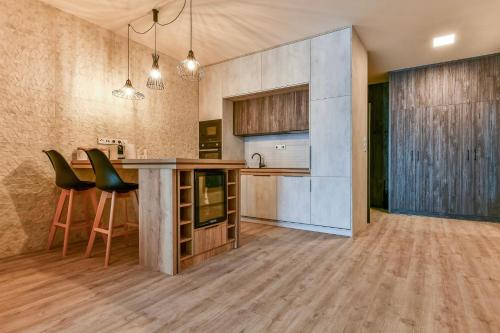a kitchen with a counter and chairs in a room at Hotel Stračena City in Ostrava