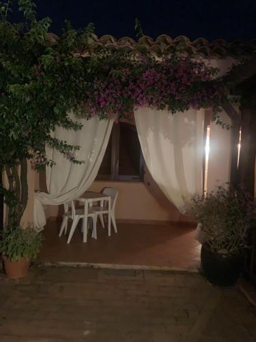 un patio nocturno con flores, mesa y sillas en Villa Turisarda en Baja Sardinia