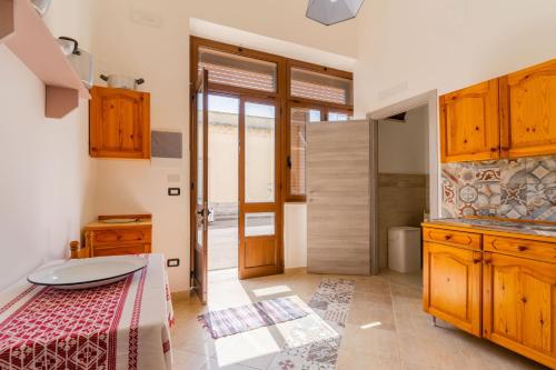 ein Schlafzimmer mit einem Bett und eine Küche mit Holzschränken in der Unterkunft Casa Vacanza Lu Sule in Uggiano la Chiesa