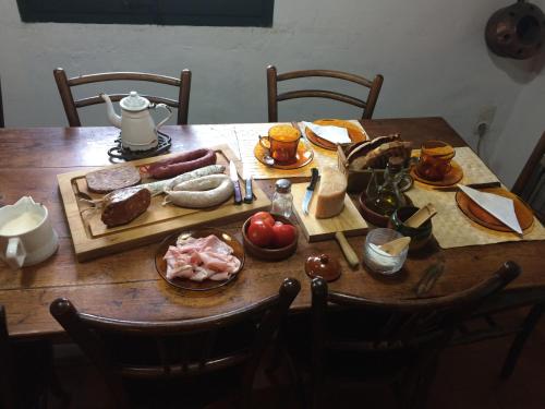 a wooden table with meat and other foods on it at Mas La Coma in Bas