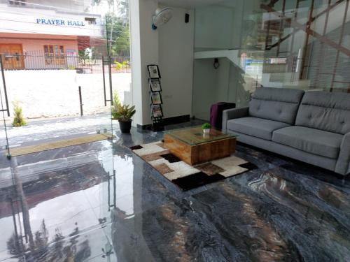 a living room with a couch and a coffee table at Hotel Centauri in Thiruvalla