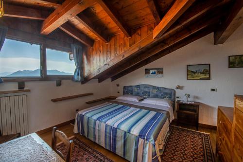 sypialnia z łóżkiem i dużym oknem w obiekcie LA CASA DI MONICA E LUCIANO w mieście Stresa
