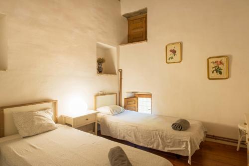 a bedroom with two beds and a table with a lamp at Can Petitu in Amer