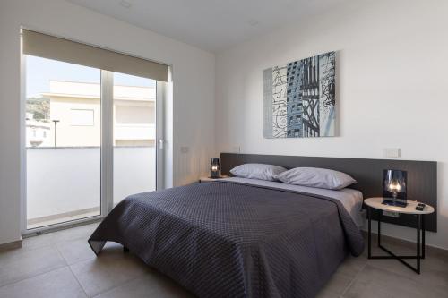 a bedroom with a bed and a large window at Oneweek Gaeta Suites and Apartments in Gaeta