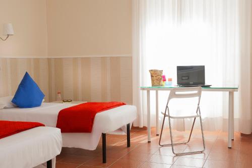 a bedroom with a bed and a desk and a chair at Budget Rooms Des Arts in Rome