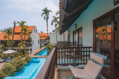 a resort balcony with chairs and a swimming pool at Khaolak Oriental Resort - Adult Only in Khao Lak