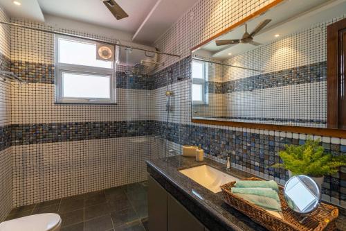 a bathroom with a sink and a mirror at StayVista at Dhauladhar House - Aesthetic 4 BHK Villa in Kangra in Dharamshala