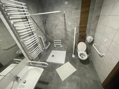 a bathroom with a white toilet and a sink at AQUARA Radomsko in Radomsko