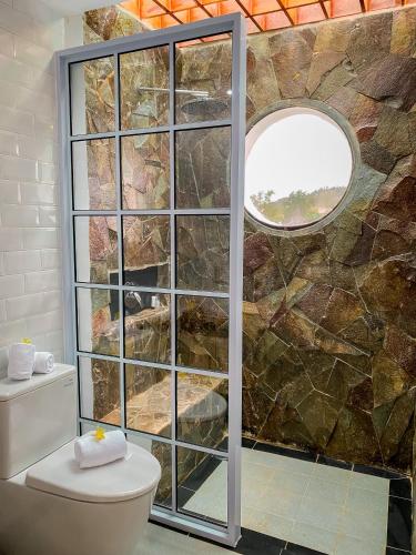 a bathroom with a stone wall and a toilet at Morelo Water Villa in Batam Center