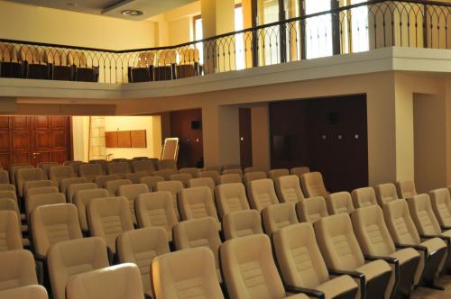 an empty auditorium with white chairs and a balcony at Bushi Resort & SPA in Skopje