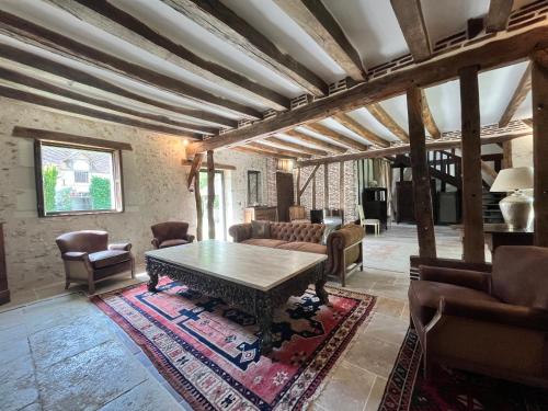- un salon avec une table et des chaises en bois dans l'établissement Cottage authentique avec piscine, à Prunay-Cassereau