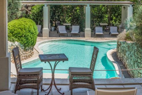 a swimming pool with chairs and a table and a table and chairs at Tenuta Aphrodite in Racale