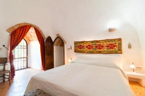 Un dormitorio con una gran cama blanca y una ventana en Tenuta Aphrodite, en Racale