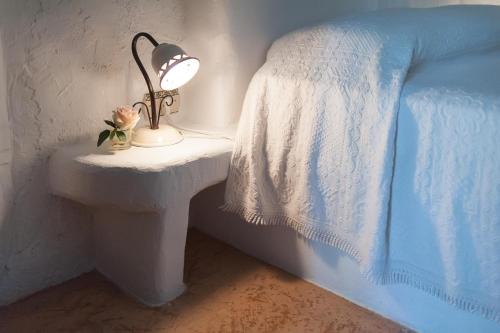 a lamp on a table next to a bed at Tenuta Aphrodite in Racale