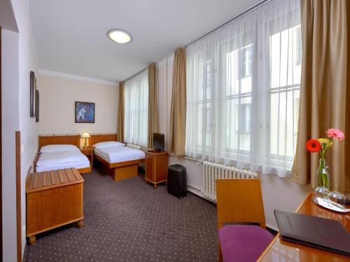 a hospital room with two beds and two windows at Hotel Melantrich in Prague