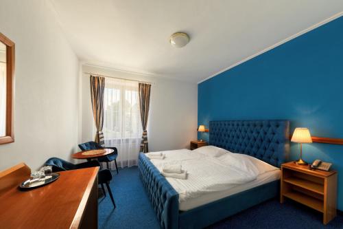 um quarto de hotel com uma cama e uma secretária em Prague Hotel Carl Inn restaurant & Free Parking em Praga