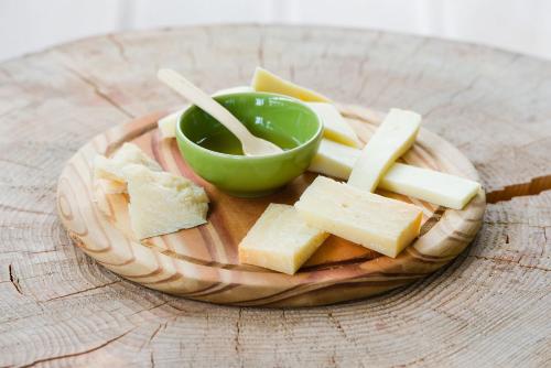 a plate of cheese and a bowl of dipping sauce at Energy Hotel in Calceranica al Lago