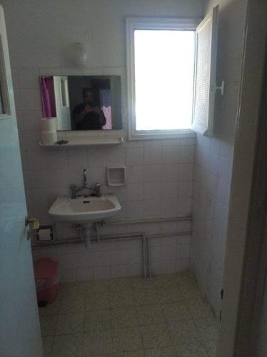 a bathroom with a sink and a person taking a picture at Ammoudia Rooms in Agia Marina Aegina