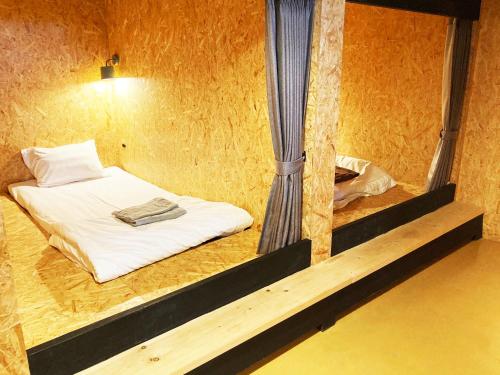 um pequeno quarto com uma cama e escadas em ADLIV/Factry Stay/工場に泊まれる em Wakimachi