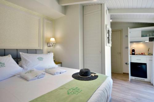 una camera da letto con un letto con un cappello sopra di CASA VERDE a Città di Corfù
