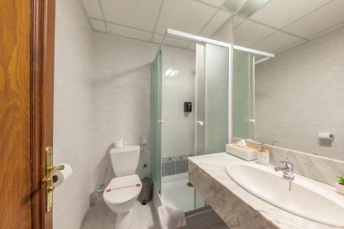 La salle de bains est pourvue de toilettes, d'un lavabo et d'une douche. dans l'établissement Prague Hotel Carl Inn restaurant & Free Parking, à Prague