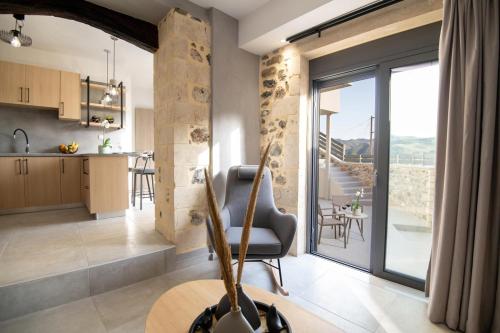 a kitchen and living room with a chair and a table at Casa Teo, By Hellocrete in Spílion
