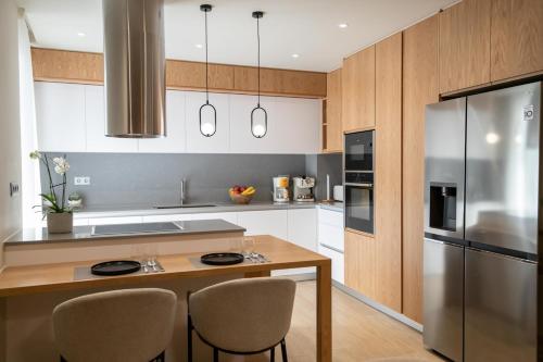 a kitchen with a wooden table and a stainless steel refrigerator at Casa Teo, By Hellocrete in Spílion