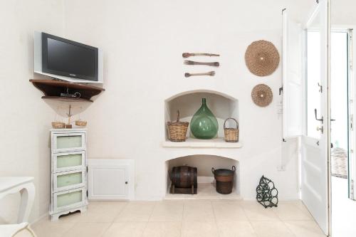 a living room with a tv and a fireplace at Tenuta Aphrodite in Racale