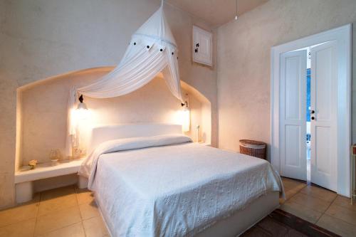 a bedroom with a white bed with a canopy at Tenuta Aphrodite in Racale
