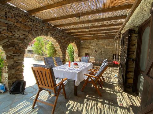 un patio con mesa y sillas bajo un techo de madera en Villa Tereza, 3-Min Walk to Koundouros Beach Waves, en Koundouros