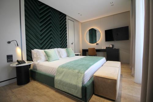 a hotel room with a large bed and a table at Rozafa Palace Hotel in Sarandë