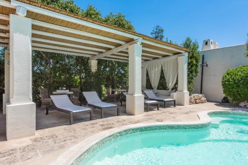 an outdoor patio with a swimming pool and a pergola at Tenuta Aphrodite in Racale