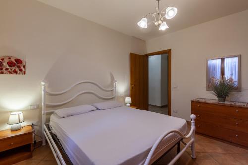 Un dormitorio con una cama blanca y una cómoda. en Casa Maria, en Lucca