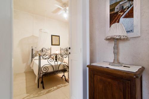 a bedroom with a bed and a lamp on a dresser at Tenuta Aphrodite in Racale