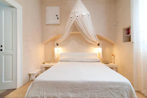 a bedroom with a white bed with a canopy at Tenuta Aphrodite in Racale