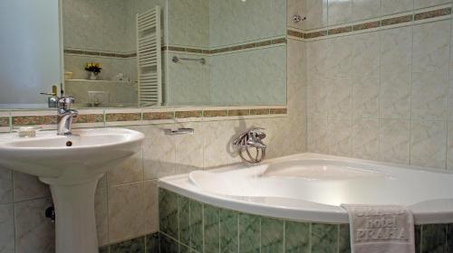 a bathroom with a sink and a bath tub at Grand Hotel Praha in Prague