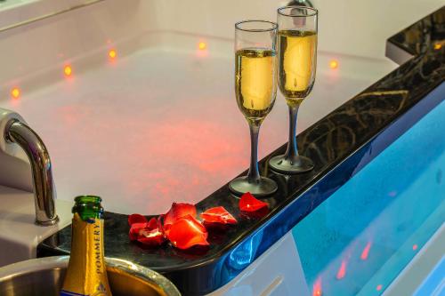 two champagne glasses on a tray next to a bath tub at Magnifique loft / spa en face de la cathédrale ! in Narbonne