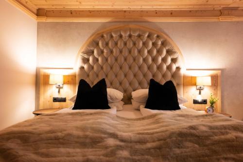 a bedroom with a large bed with a large headboard at Hotel Winterbauer in Flachau