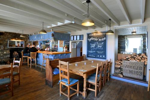 ein Restaurant mit einem Tisch und Stühlen sowie einer Bar in der Unterkunft Ship Inn in Aberporth