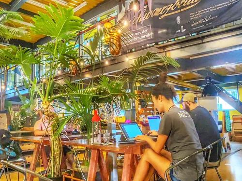 a group of people sitting at a table with laptops at ADLIV/Factry Stay/工場に泊まれる in Mima