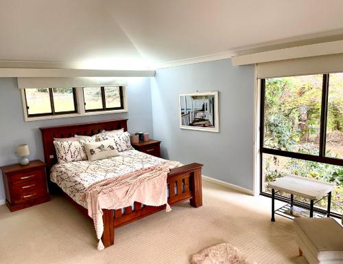 a bedroom with a bed and a large window at Tamborine Mountain Lodge in Mount Tamborine