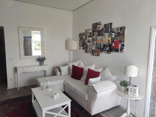 a white living room with a white couch and a table at Petite Maison in Vignanello