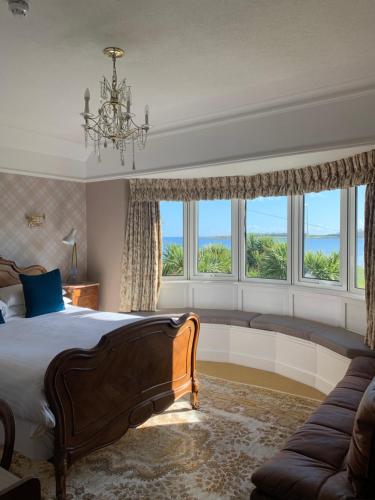 a bedroom with a bed and a couch and windows at Cairn Bay Lodge in Bangor