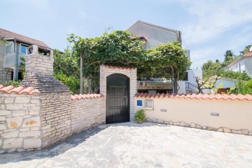 a gate in a brick wall with a door at Apartments Nataša in Supetar