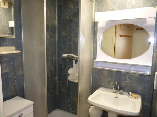 une salle de bain avec un lavabo et un miroir dans l'établissement Sol-y-Days Californie, Appartement confortable 4 personnes à 300m de la plage, au Grau-du-Roi