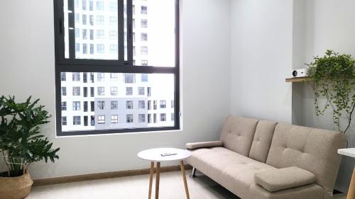 a living room with a couch and two windows at Bcons Garden Luxury Aparment in Dĩ An