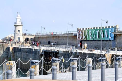 a pier with a light house and a lighthouse at Beautifully appointed, period seaside apartment in Folkestone
