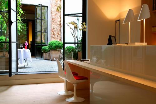 un bancone con due sedie e un tavolo in una stanza di Hotel Julien ad Anversa