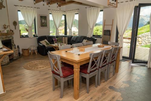 a kitchen and living room with a wooden table and chairs at Casa de Sub Munte Fundata in Fundata